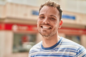 Obraz premium Young hispanic man smiling confident standing at street