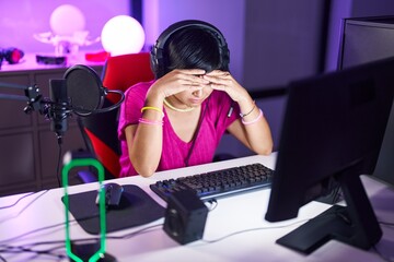 Middle age chinese woman streamer stressed using computer at gaming room