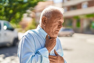 Senior grey-haired man standing suffering for heart attack at street - obrazy, fototapety, plakaty