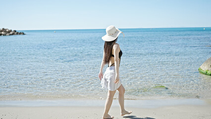Young chinese woman tourist wearing swimsuit and summer hat at seaside