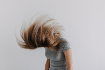 Asian Thai woman wear grey, shanking off and flinging messy hair, isolated on white background wall.
