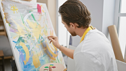 Young hispanic man artist drawing concentrated at art studio