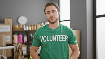 Young hispanic man volunteer standing withe serious face at charity center