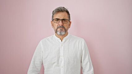 Chill vibes overload! young grey-haired hispanic man oozes cool, relaxed expression while standing, isolated over pink background. definitely that handsome adult male, rocking casual fashion! - obrazy, fototapety, plakaty