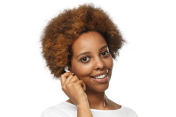 Portrait of smiling young african american woman listening to music with wireless earphones, wearing white t-shirt