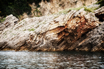 Sharp cliff and mountains cut close to the dark sea water. Beautiful nature backgrounds