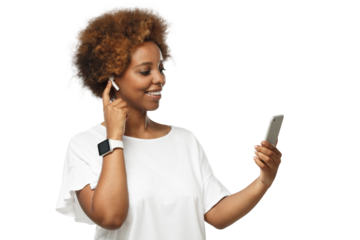 Young african american woman listening to music via wireless earphones, using music streaming service app on phone