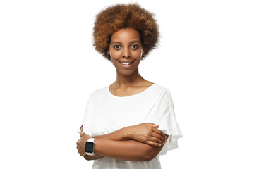 Smiling young african american woman wearing white t-shirt and smartwatch on one of crossed arms