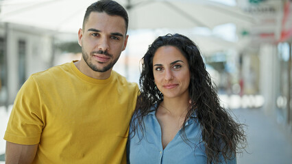 Naklejka premium Man and woman couple standing together with relaxed face at street