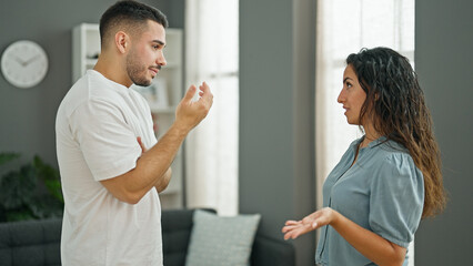 Obraz premium Man and woman couple standing together arguing at home