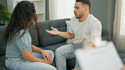 Fototapeta premium Man and woman sitting on sofa having couple therapy at psychology clinic