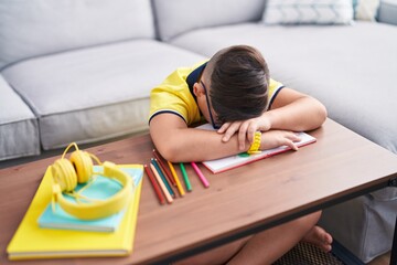 Adorable hispanic boy unhappy with head on table at home