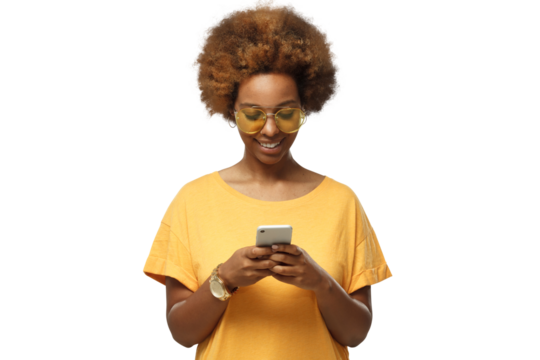 African american woman standing, looking at screen of phone, surfing web and smiling while browsing content