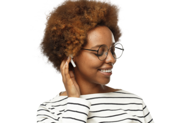 Smiling black woman wearing glasses, touching her afro hair, listening to her favorite music via wireless earphones