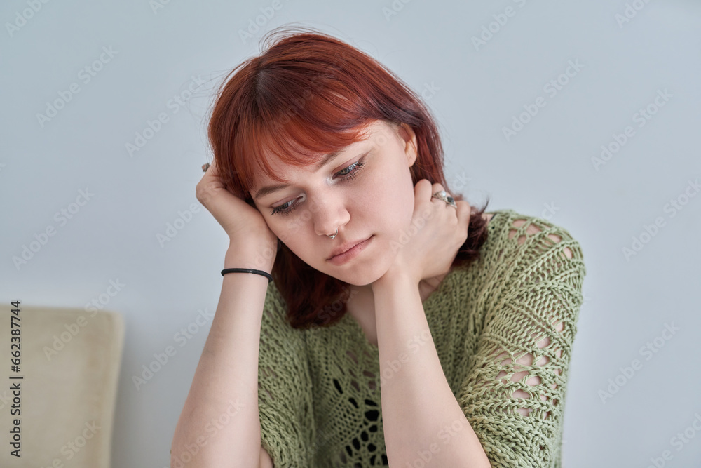 Wall mural Sad upset teenage female, red-haired girl 19, 20 years old face close-up