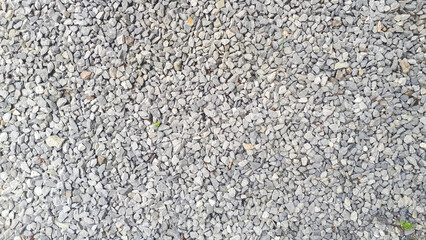  Close-up detail of small pebbles creating a textured pattern on a gravel road. - 662388722