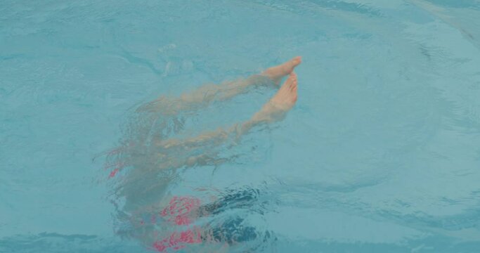 attractive woman swimming under water, diving in blue water Slow motion, unhappy sad girl breaking nail while swimming process. She is having an amazing holiday