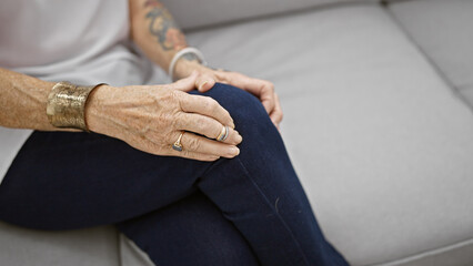Elderly woman suffering tremendous knee pain, adult, resting despondently in the comfort of her...