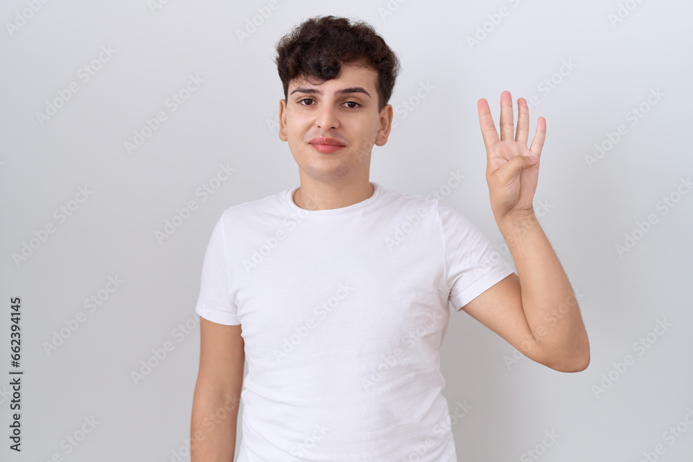 Canvas Prints Young non binary man wearing casual white t shirt showing and pointing up with fingers number four while smiling confident and happy.