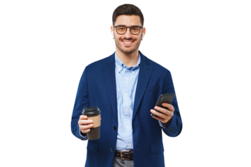 Handsome young businessman holding phone in one hand and paper coffee cup in another, looking at camera and smiling
