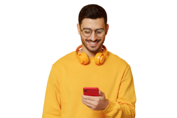 Young man looking at screen of his phone, wearing yellow sweatshirt and wireless headphones, using music app