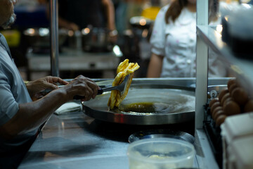 Roti Making, roti thresh flour by roti maker with oil. Thai Pancake topped with sweetened condensed...