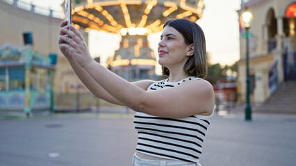 Young beautiful hispanic woman taking pictures with smartphone at Prater Vienna