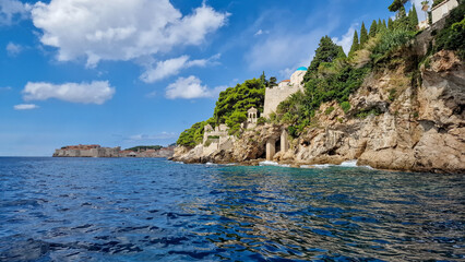 Fototapeta premium Beautiful view of the rocky coast in Croatia, with the city of Dubrovnik in the background, summer 2023