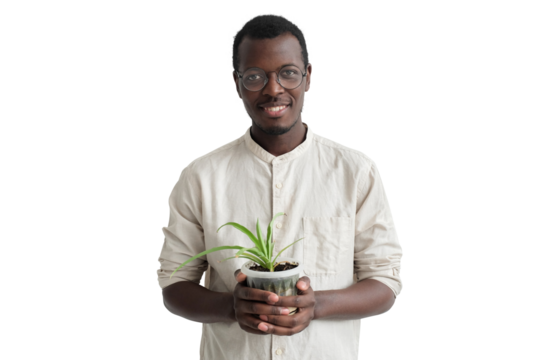 Young smiling african man holding flower pot with green plant in hands