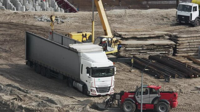 Unloading a truck at a construction site. At a construction site, a crane unloads reinforcement.