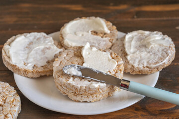 Whole grain rice cake covered with cream cheese.

