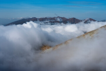 Dancing in the clouds, i.e. a panorama of the High Tatras - Slovakia. The hiking trail to Krywan. Mountains crowded by fog during autumn. Exposed mountain ridge. 