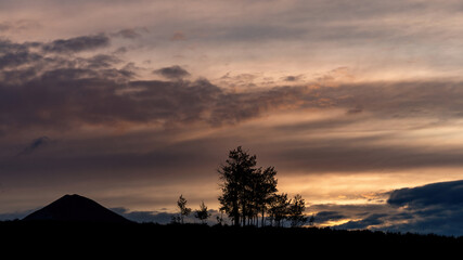 Sunset silhouette with trees and mountain