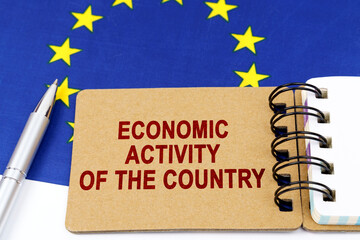 On the flag of the European Union lies a pen and a notepad with the inscription - economic activity...