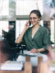 Young smiling woman talking on smartphone with closed eyes