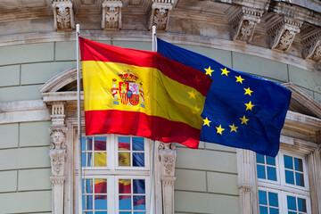 Flags of Spain and Europe waving outside a building
