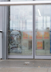 broken glass door after impact. Damaged shop window - obrazy, fototapety, plakaty
