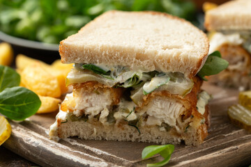 Fish Finger Sandwich on wooden board with potato fries