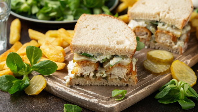 Fish Finger Sandwich on wooden board with potato fries
