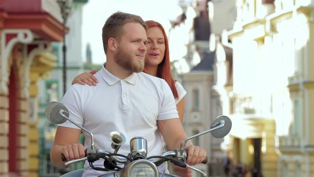 Beautiful young couple riding scooter together