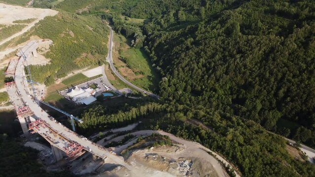 Highway bridge under construction. Aerial view of nes road. Freeway being built on a mountain terrain..
