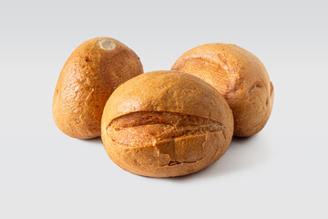 Three round buns with a golden crust and a cut on top