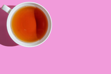 Top view of teacup on purple background with copy space.