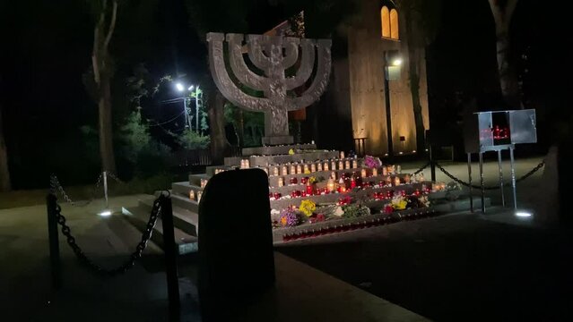 Menorah monument in Babiny Yar in Kyiv, night time Holocaust Remembrance Day. Honoring the victims of the Second World War. Candle fire, memory of the shot dead. High quality 4k footage