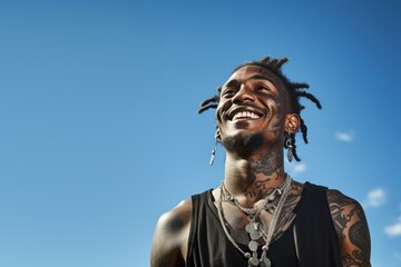 Young black man with neck and face tattoos smiling having hope