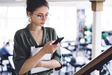 Female student with tablet browsing cellphone
