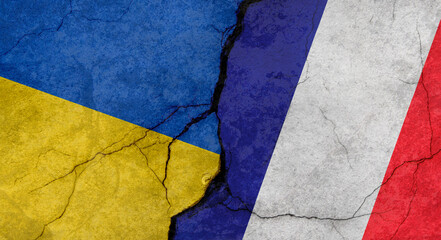 Ukraine and France flags, concrete wall texture with cracks, grunge background, military conflict concept
