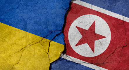 Ukraine and North Korea flags, concrete wall texture with cracks, grunge background, military conflict concept