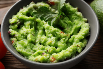 Delicious guacamole with parsley on table, closeup