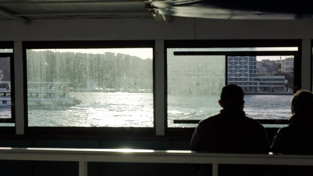 Back View of Couple Travelling In Ferry on Sea. Dusty window, Boat on Background